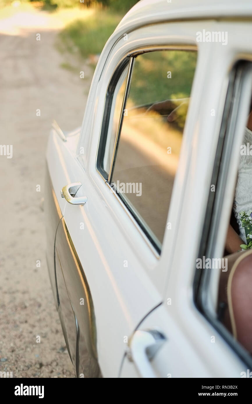 Vista sulla porta del passeggero di un'auto d'epoca del colore bianco. Foto Stock