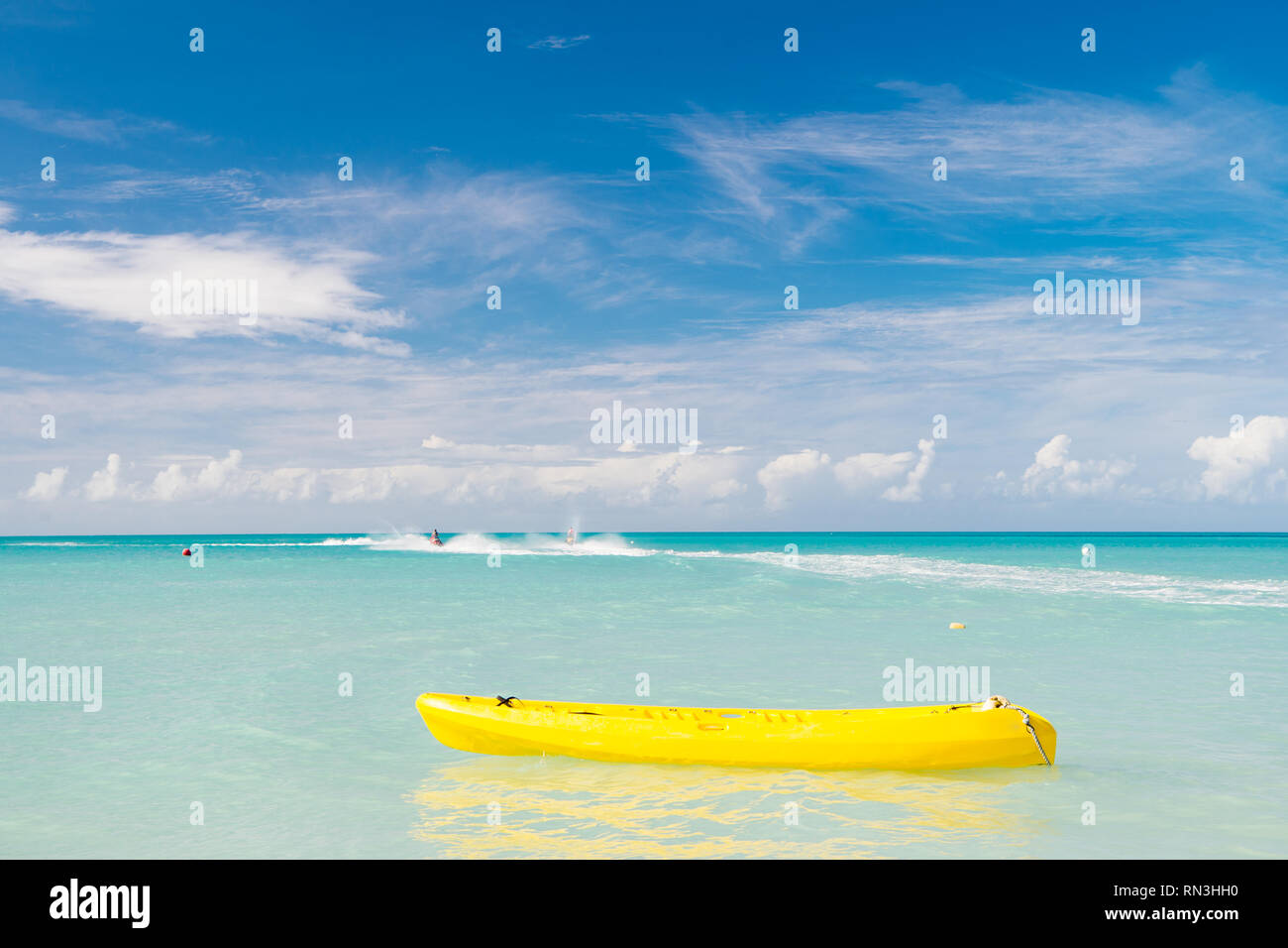 Vista brillante di esotica colorata bella spiaggia di Marina di Antigua St. Johns con barca giallo su blu acqua e cielo con piccole nuvole nel tempo soleggiato outdoor su Foto Stock