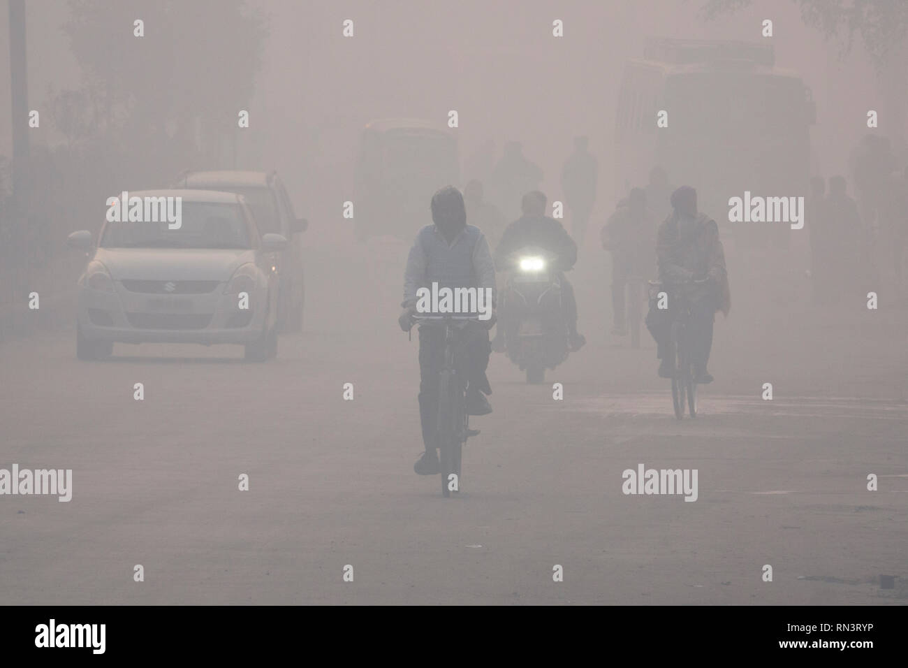 Popolo Indiano che si occupano di pericolosi livelli di inquinamento atmosferico in Amritsar Punjab, India Foto Stock