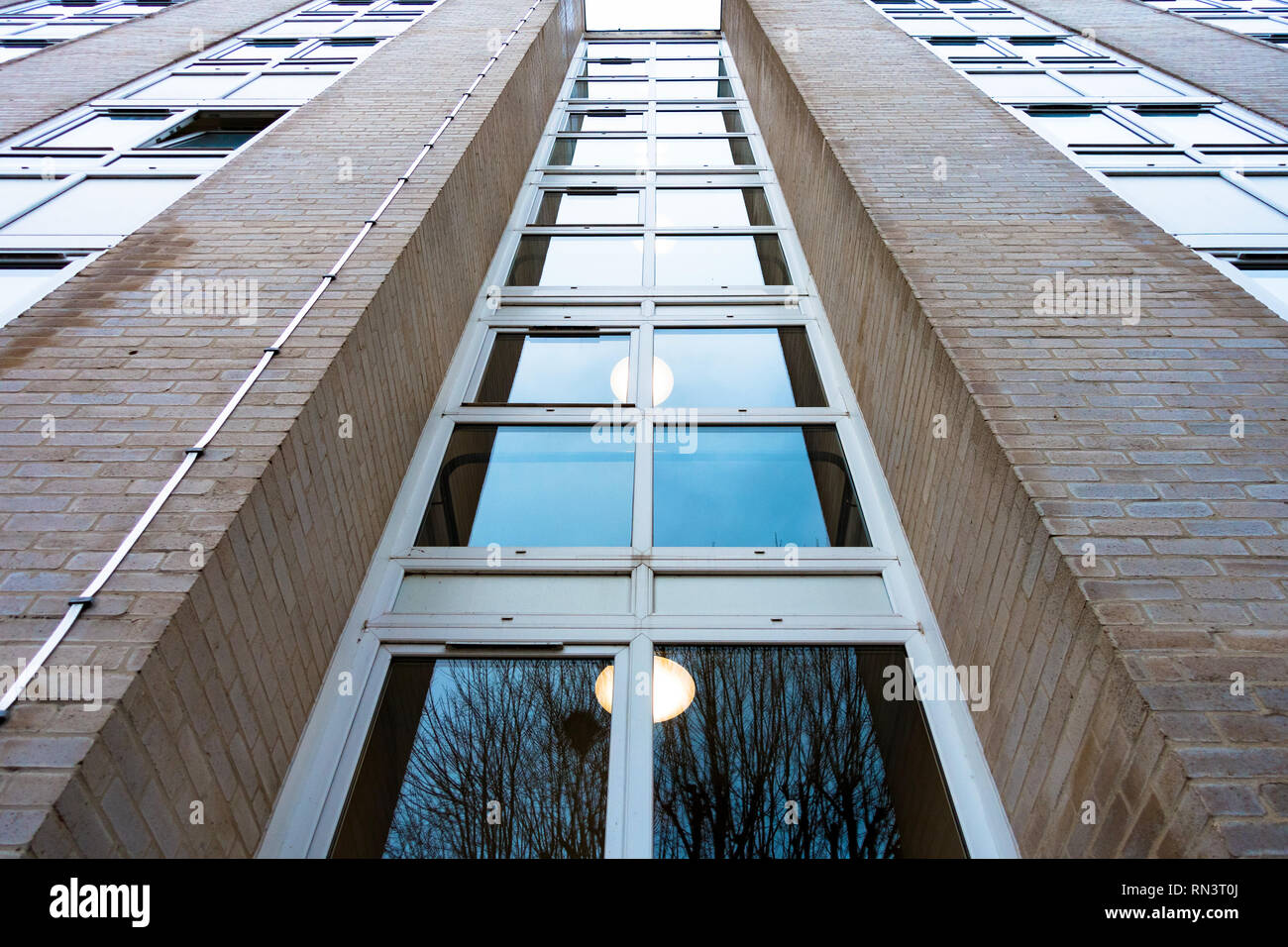 Guardando verso l'alto una colonna di windows incorporato nella struttura di un blocco di appartamenti. Foto Stock