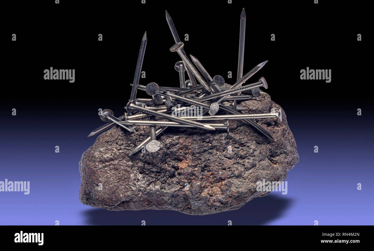 La magnetite attirare chiodi di ferro Foto Stock