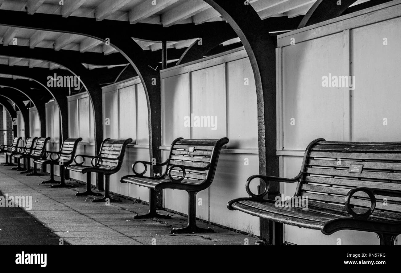 Una fila di panche sotto un riparo Foto Stock