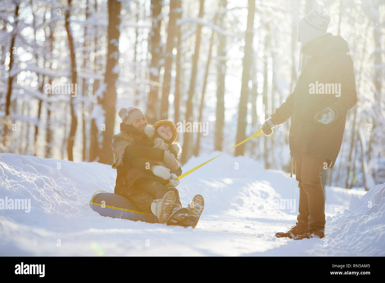 La famiglia felice godendo Sleigh Ride Foto Stock