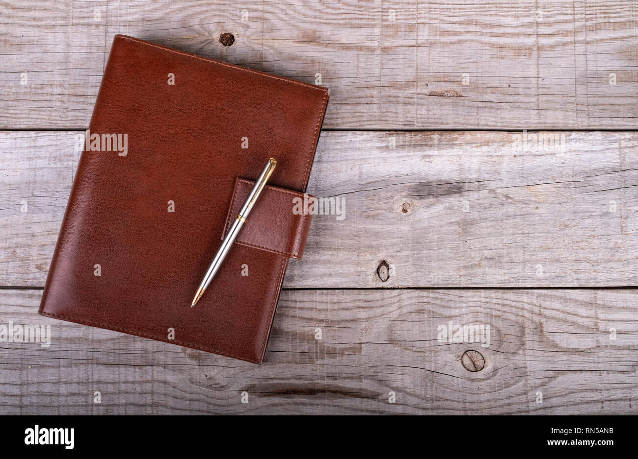 Imprenditore il agenda e penna su sfondo di legno Foto Stock