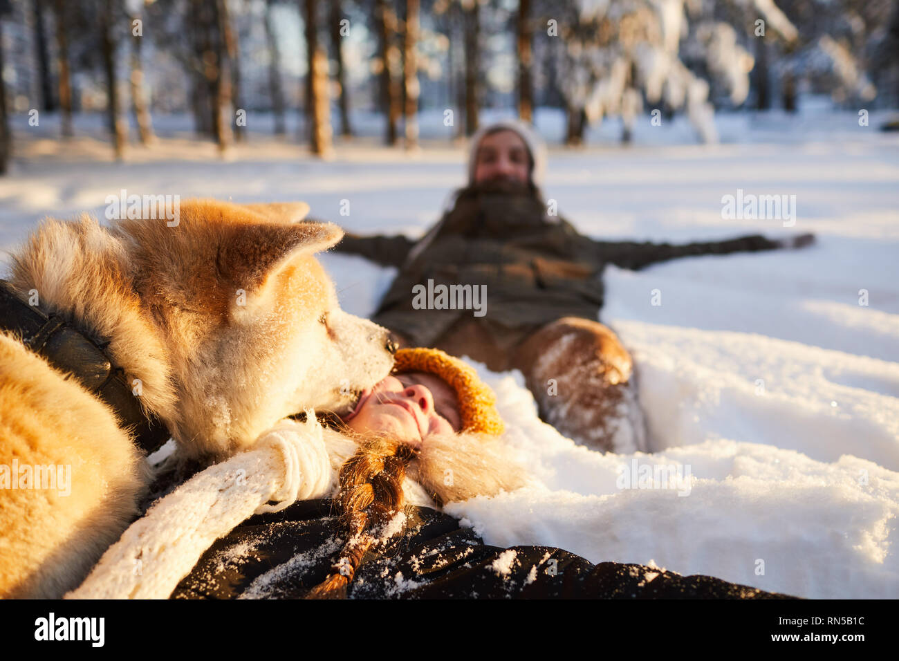Ragazza che gioca con il cane nella neve Foto Stock