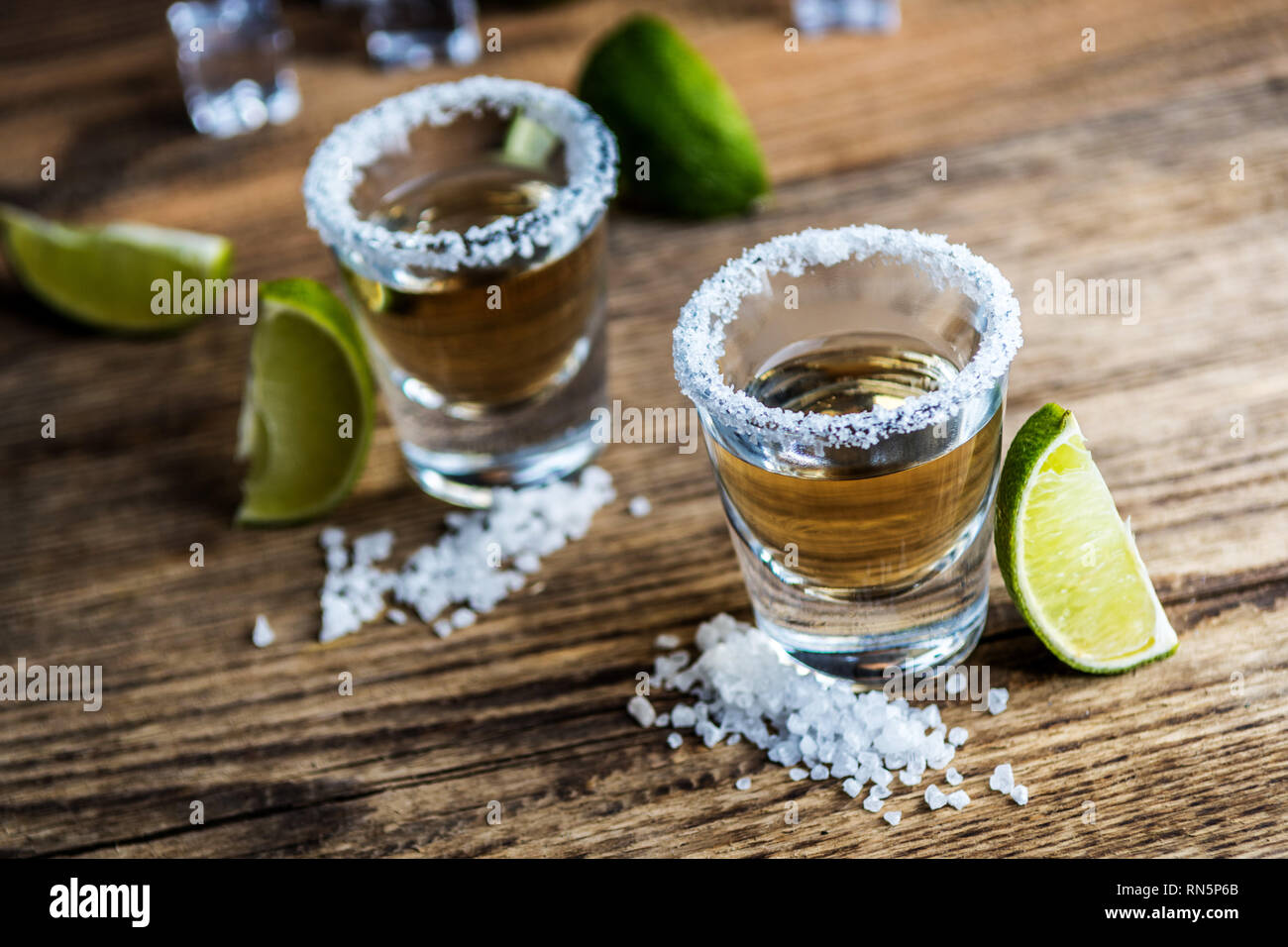 Tradizionale messicano alcool bere la tequila con calce e sale e cubo di ghiaccio sul tavolo di legno Foto Stock