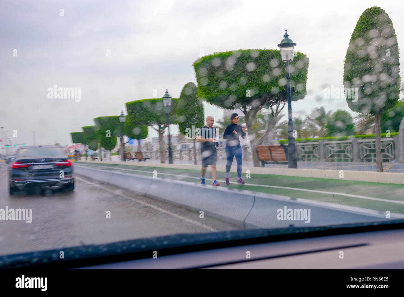 Abu Dhabi, negli Emirati Arabi Uniti. Xvii Feb, 2019. Giovane Jogging durante la pioggia alla Corniche Road Abu Dhabi. Credito: Fahd Khan / Alamy News Live Credito: Fahd Khan/Alamy Live News Foto Stock