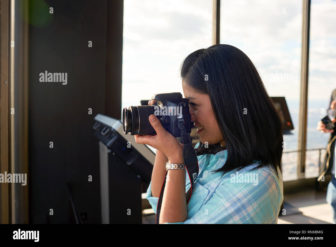 CHICAGO, IL - circa marzo, 2016: coperta ritratto di donna con fotocamera digitale a John Hancock Center dell'Osservatorio. Il John Hancock Center è un super Foto Stock