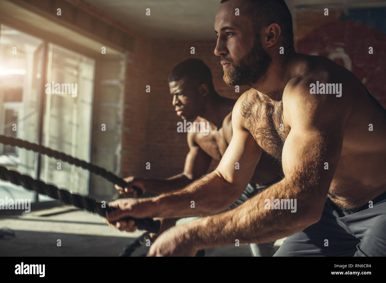 Muscolare di semi-corpo nudo atleti facendo alcuni esercizi crossfit con  una corda al coperto, la preparazione per concorsi e masterizzazione in  modo efficace il grasso in eccesso Foto stock - Alamy