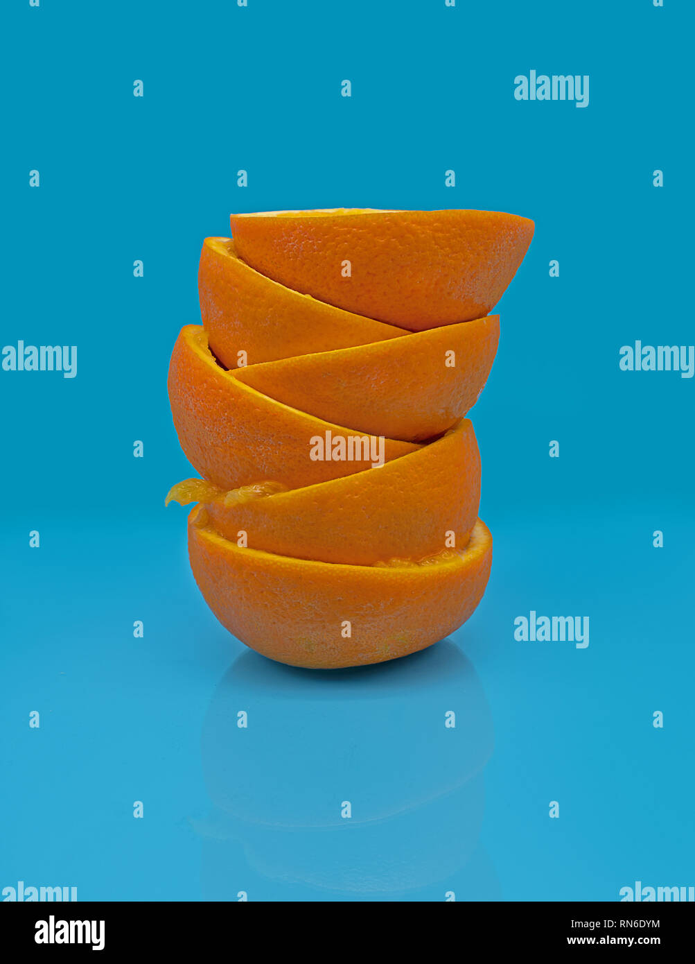 Spremuto metà arancione di fronte a uno sfondo blu Foto Stock
