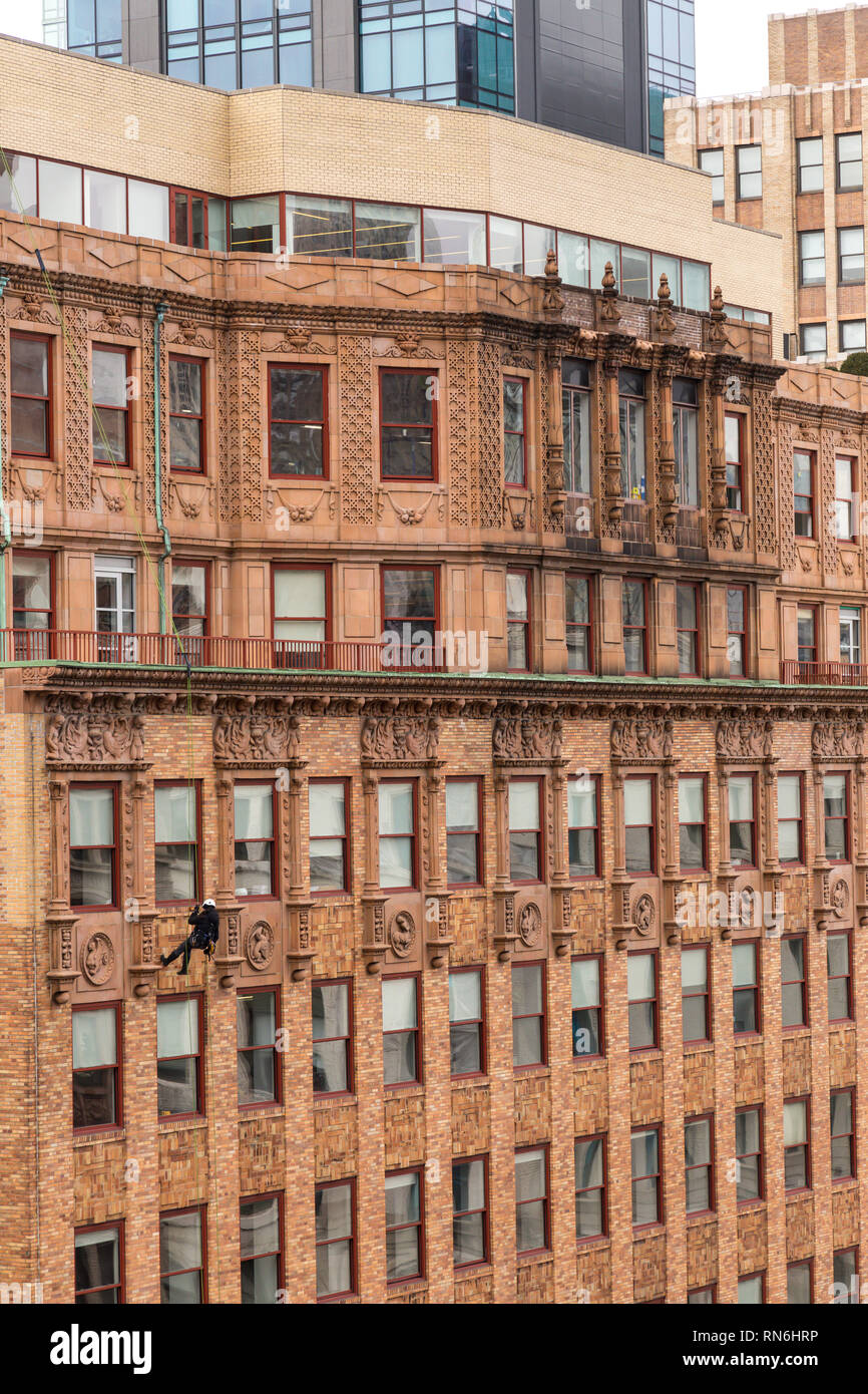 Ingegnere Industriale rappelling lungo il lato di un edificio su un ispezione strutturale, New York City, Stati Uniti d'America Foto Stock
