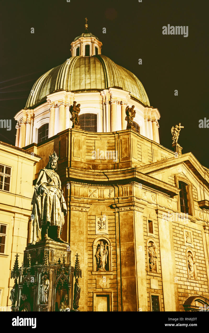 Carlo IV la statua e la chiesa di San Francesco di Assisi a Praga, Repubblica Ceca. Scena notturna. Architettura religiosa. Destinazione di viaggio. Giallo pho Foto Stock