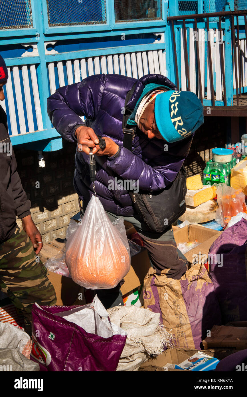 Np984 Nepal, Namche Bazaar, Mercato trader di peso borsa di plastica grande di lenticchie per vendita, utilizzando la bilancia a molla Foto Stock Np984 Nepal, Namche Bazaar, Mercato trader di peso borsa di plastica grande di lenticchie per vendita, utilizzando la bilancia a molla Foto Stock