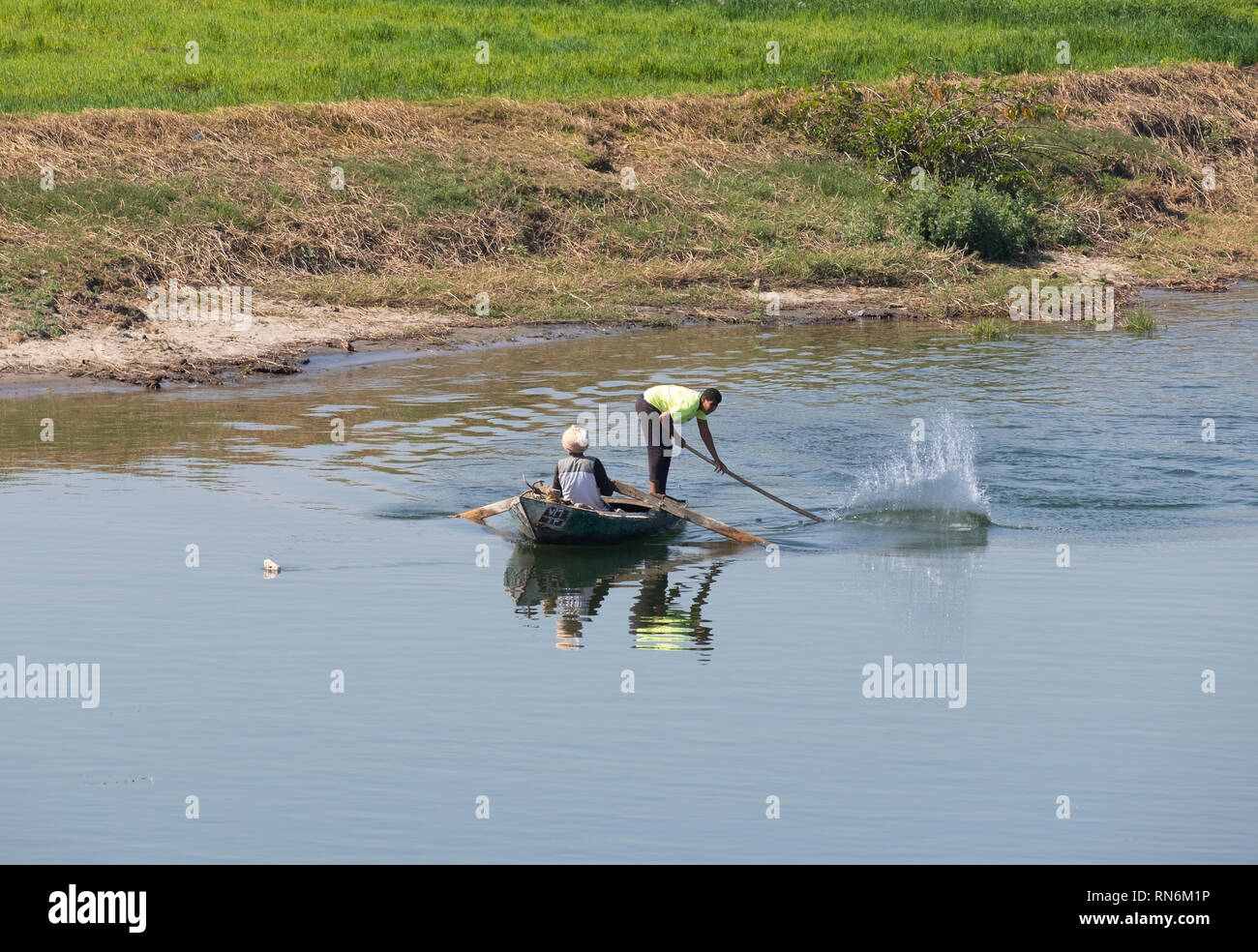 Il fiume Nilo in Egitto, gli uomini la pesca dalla barca piccola, colpendo ad acqua per spaventare i pesci nel loro net. Un antica tecnica per la cattura del pesce. Foto Stock