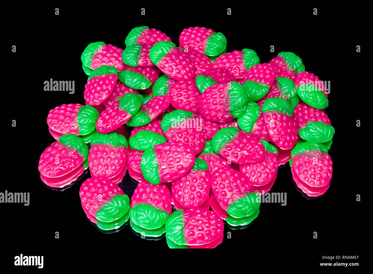 Caramelle colorate fragole con mirror su uno sfondo nero. Foto Stock
