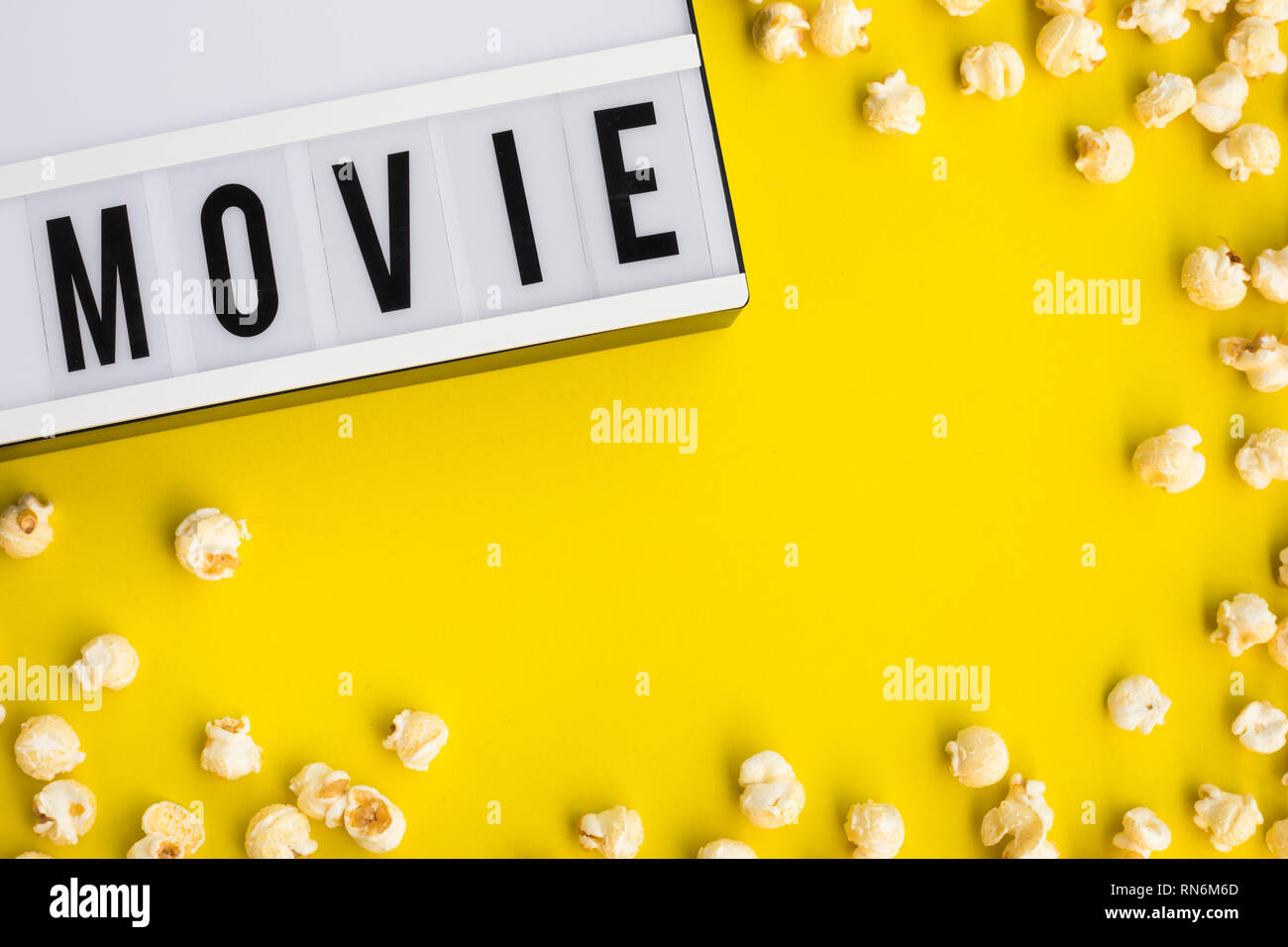 Testo del filmato sulla scatola di luce con pop corn sui colori pastello sfondo.il cibo e snack concetti idee.Stile minimal Foto Stock
