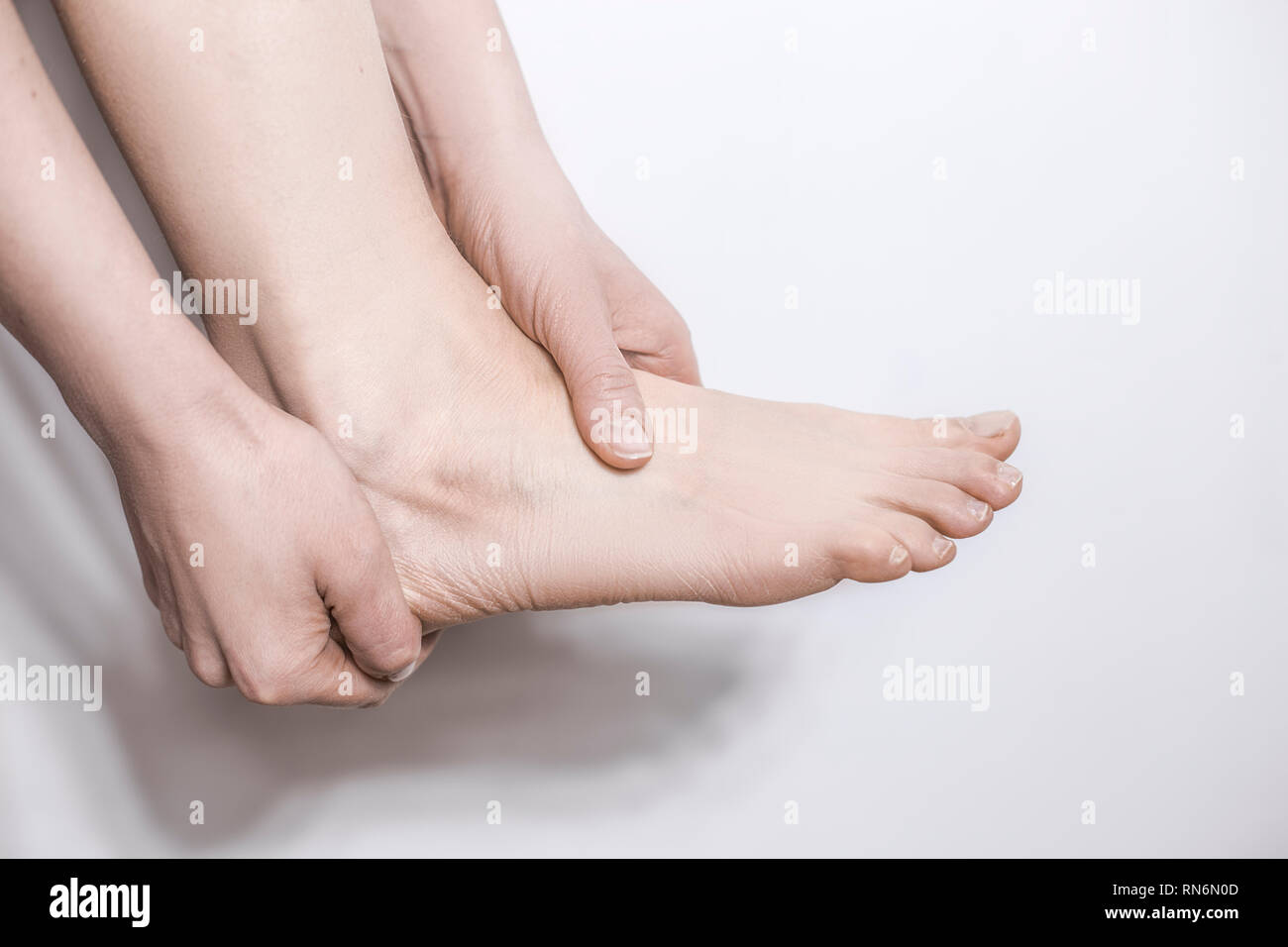 Tenere le mani mal di tacco della caviglia. Il trauma per il giunto. Foto Stock