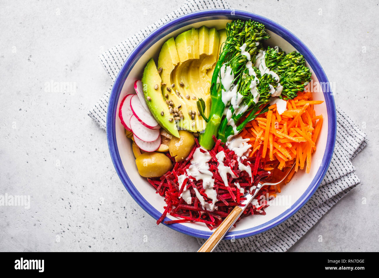 Rainbow vegane insalata con barbabietole, carote, avocado, broccolini, olive e tahini spogliatoio, vista dall'alto. Foto Stock