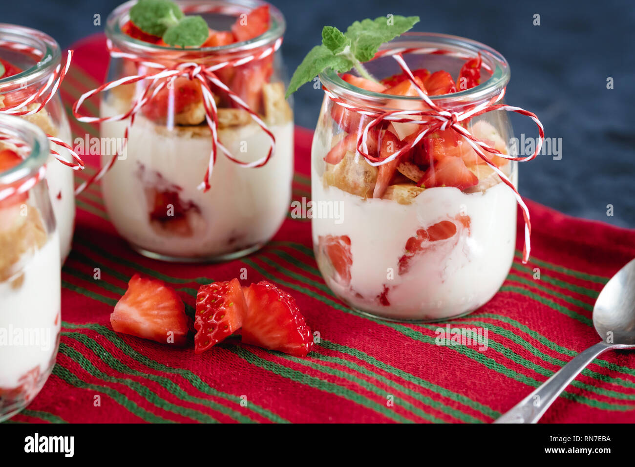 Yogurt con fragole fresche e i biscotti sminuzzati in un vaso. Foto Stock