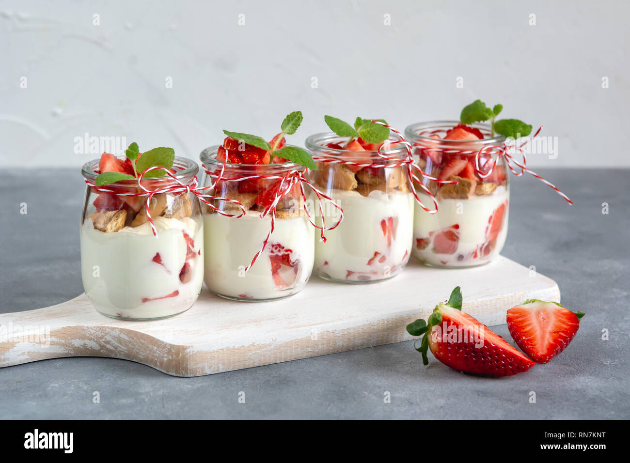 Yogurt con fragole fresche e i biscotti sminuzzati. Una sana prima colazione. Foto Stock