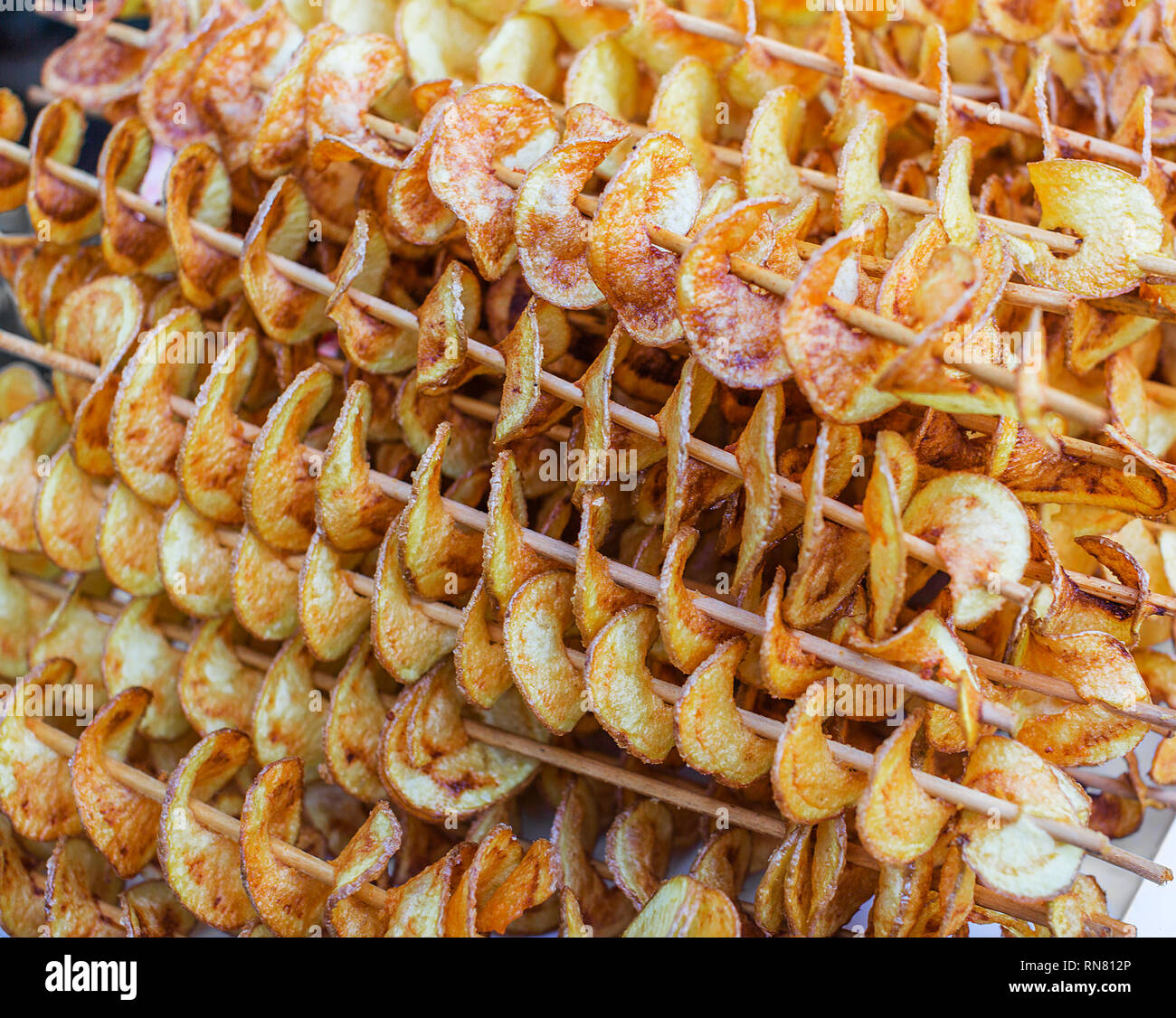Street fast food. Spirale potato chips su bastoni Foto stock - Alamy