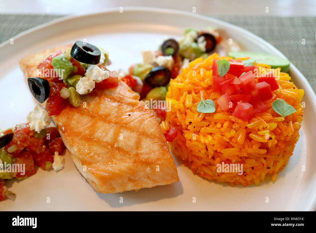 In stile greco in padella il salmone con Avocado, pomodori, olive nere, il  formaggio Feta e insalata di riso allo zafferano Foto stock - Alamy