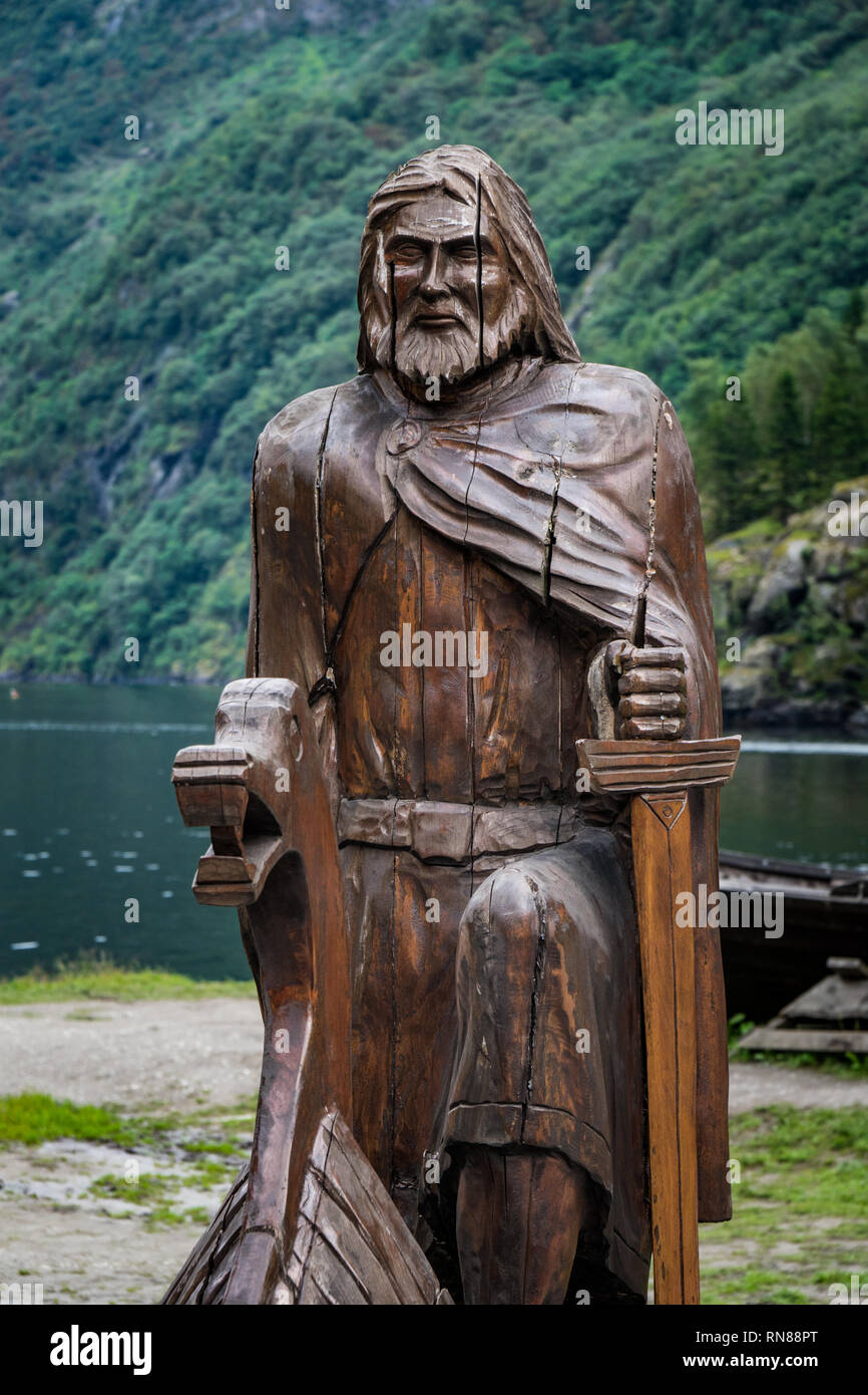 Scultura in legno norse viking sailor con la montagna e le foreste in background. Foto Stock