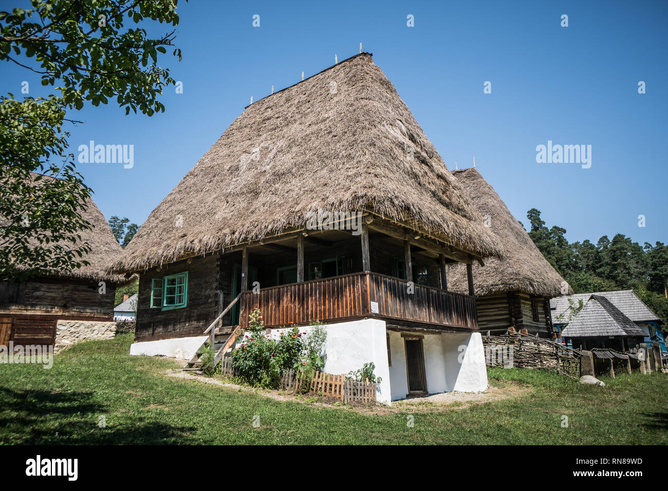 Tradizionale villaggio rumeno home con erba tetto di fieno in Folk Museum vicino a Sibiu. Foto Stock