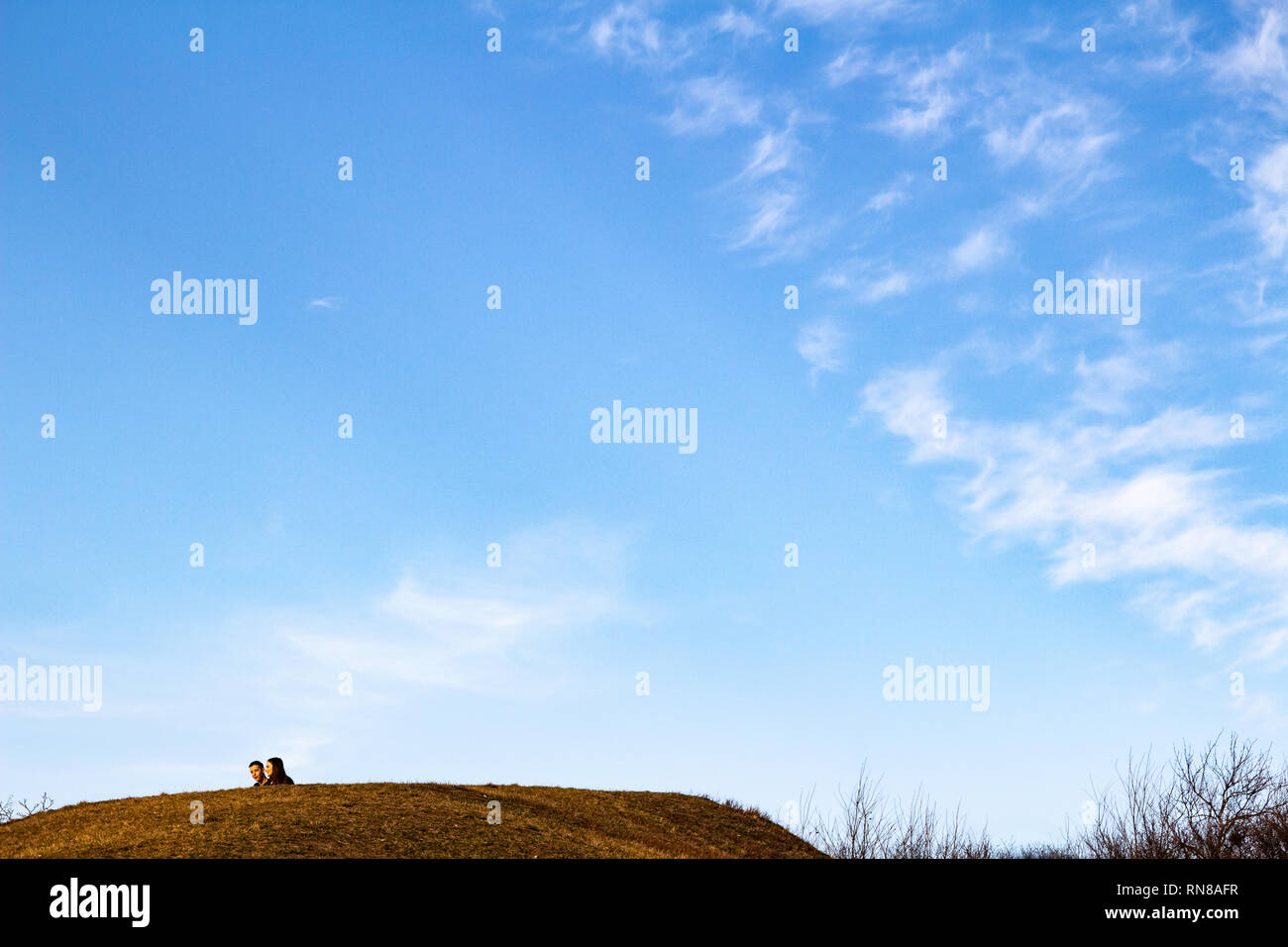 Coppia giovane di testa dietro la collina con un cielo blu e cirro-stratus nuvole Foto Stock