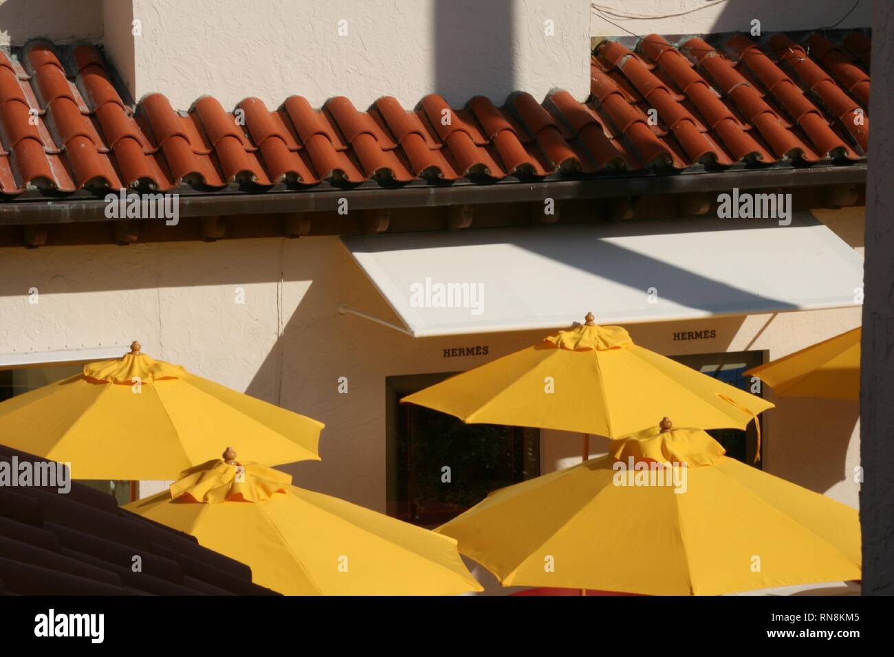 Gli ombrelli gialli proteggono i clienti dal sole caldo. Foto Stock