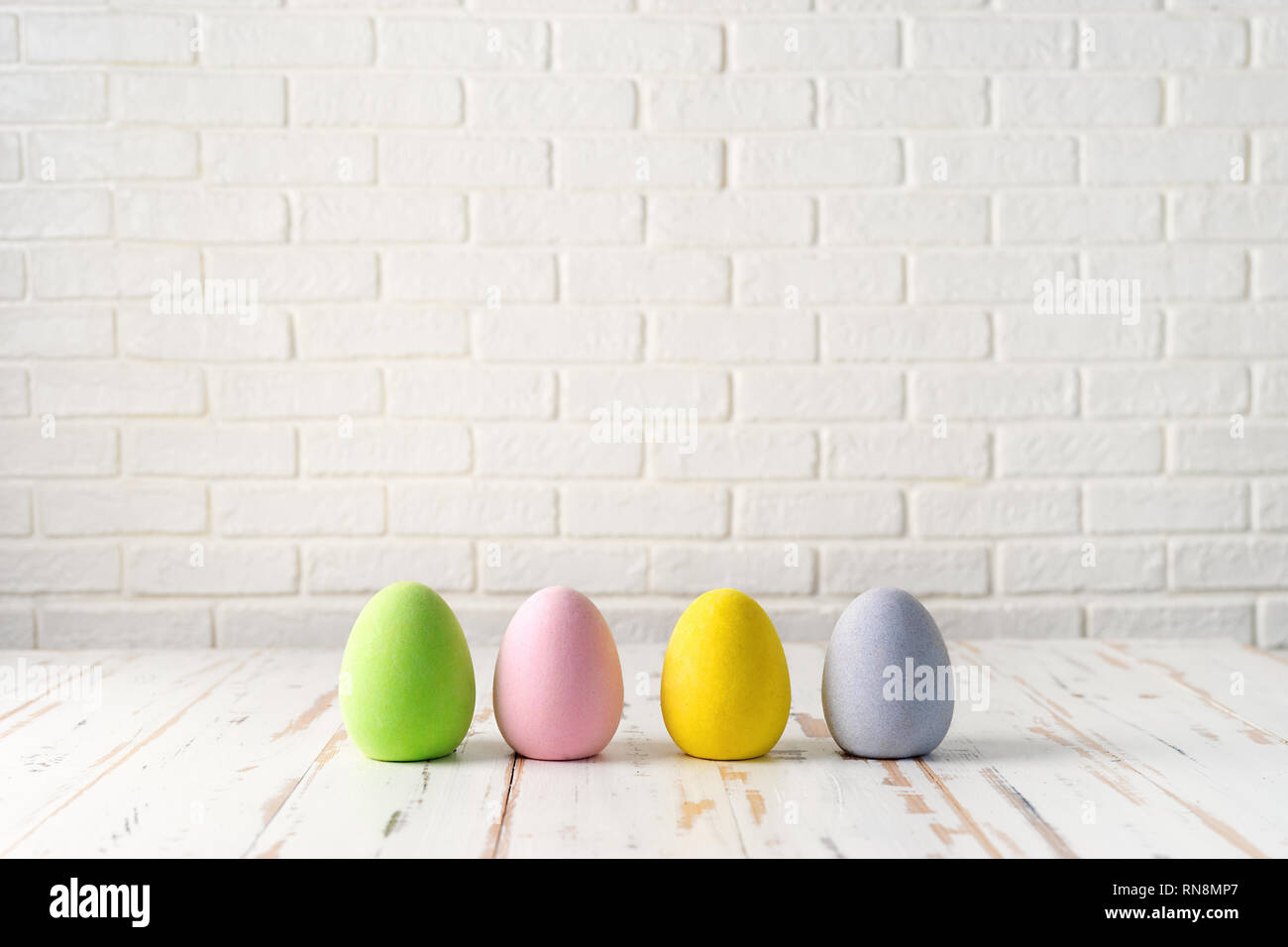 Quattro uova di Pasqua bianco contro il muro in mattoni Foto Stock