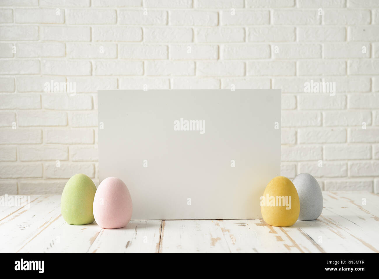 Composizione di pasqua con uova, bianco bordo bianco contro il muro in mattoni Foto Stock