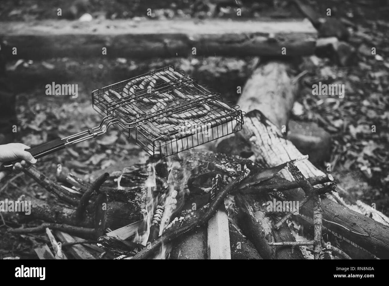 In autunno il barbecue nella natura - salsicce fritte sul fuoco. Foto Stock