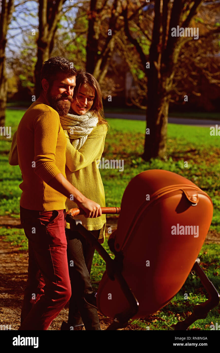 Genitori felici godere di paternità. I genitori di passeggiata baby pram nel soleggiato parco. Il primo la felicità di un bambino a sapere che egli è amato Foto Stock