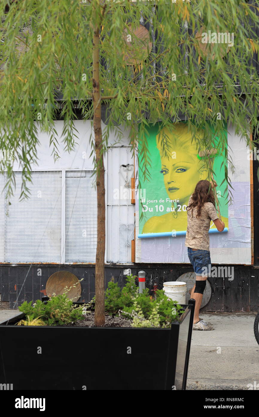Quebec, Canada. Una persona giovane mettendo su un poster in Montreal Gay Village. Foto Stock