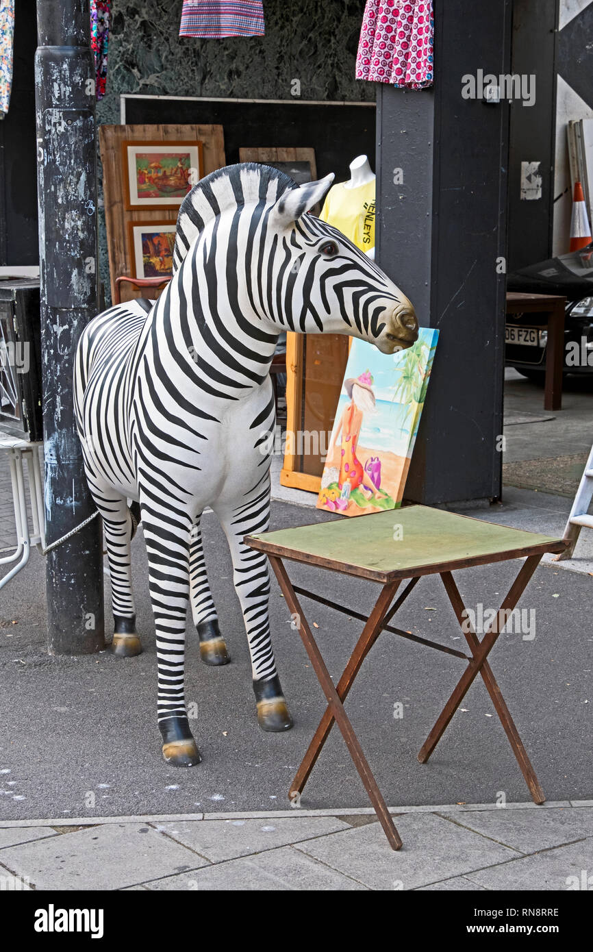 Una scultura di una zebra si erge al di fuori di un negozio di anticaglie in Stokes Croft area di Bristol, Regno Unito. Foto Stock