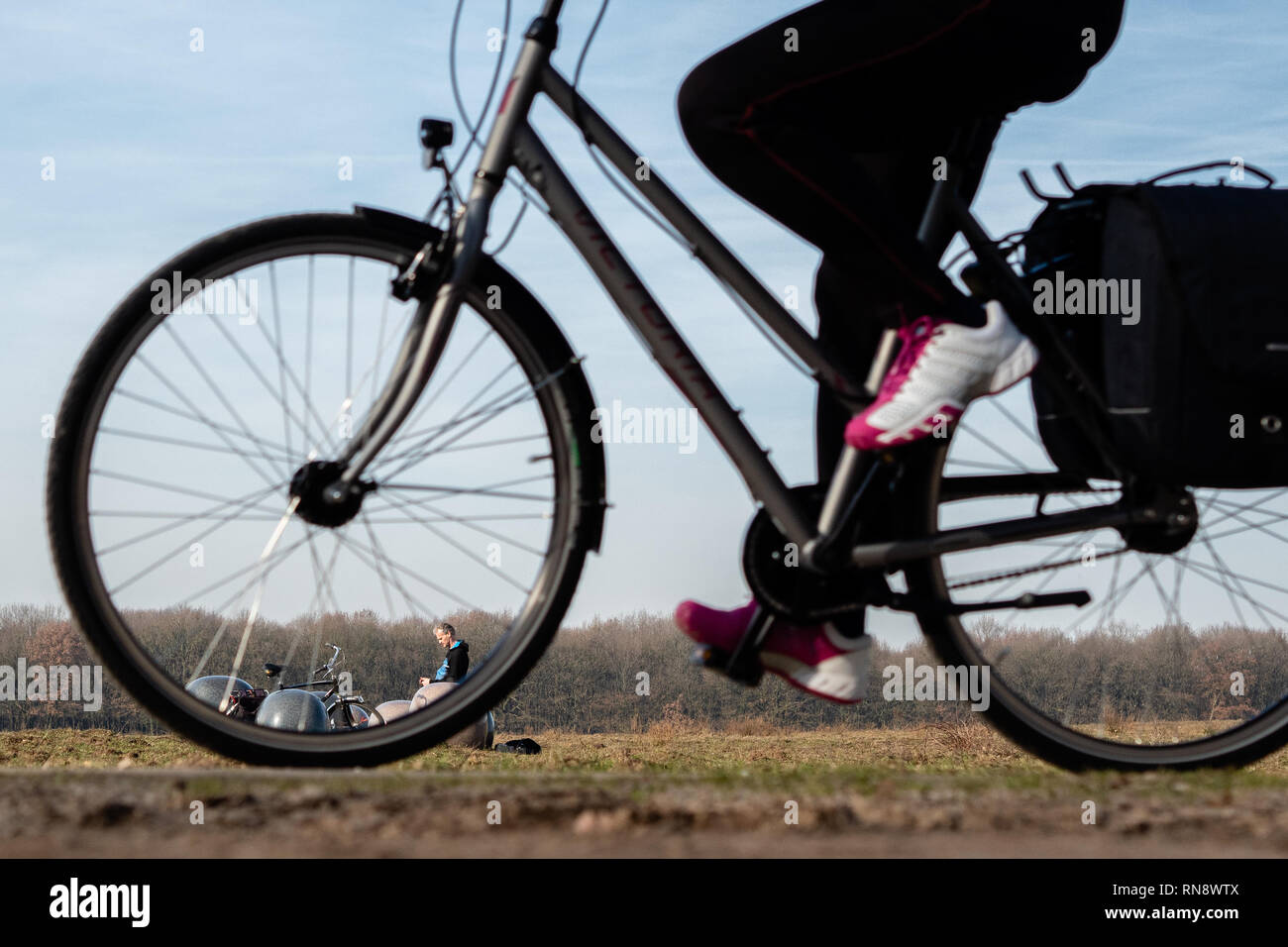 Un uomo è visto in sella ad una bicicletta durante una giornata di sole. Foto Stock