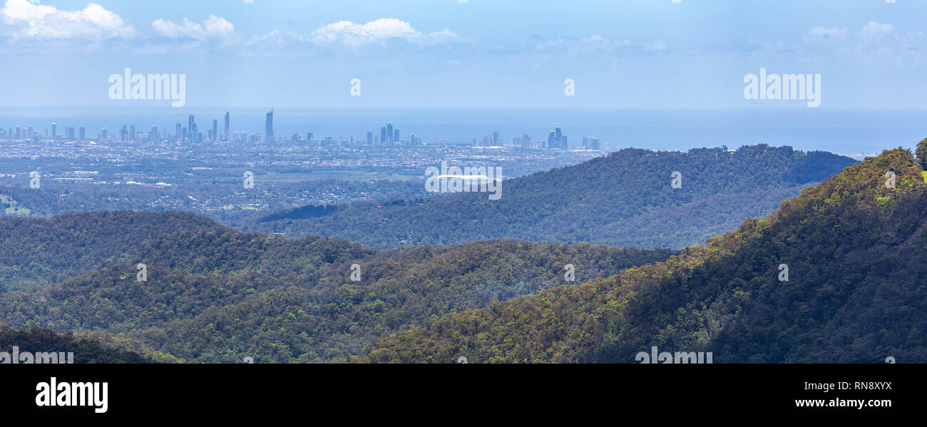 Verdi colline coperte di boschi e la Gold Coast Città sullo sfondo visto dalla Springbrook National Park in Queensland, Australia Foto Stock