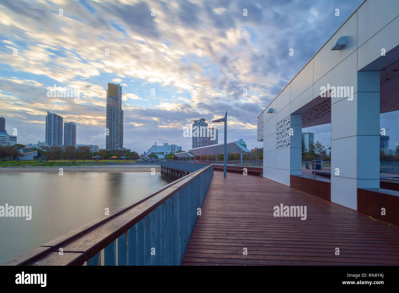 Il molo di legno e luxury real estate alto al tramonto. Southport, Queensland, Australia Foto Stock