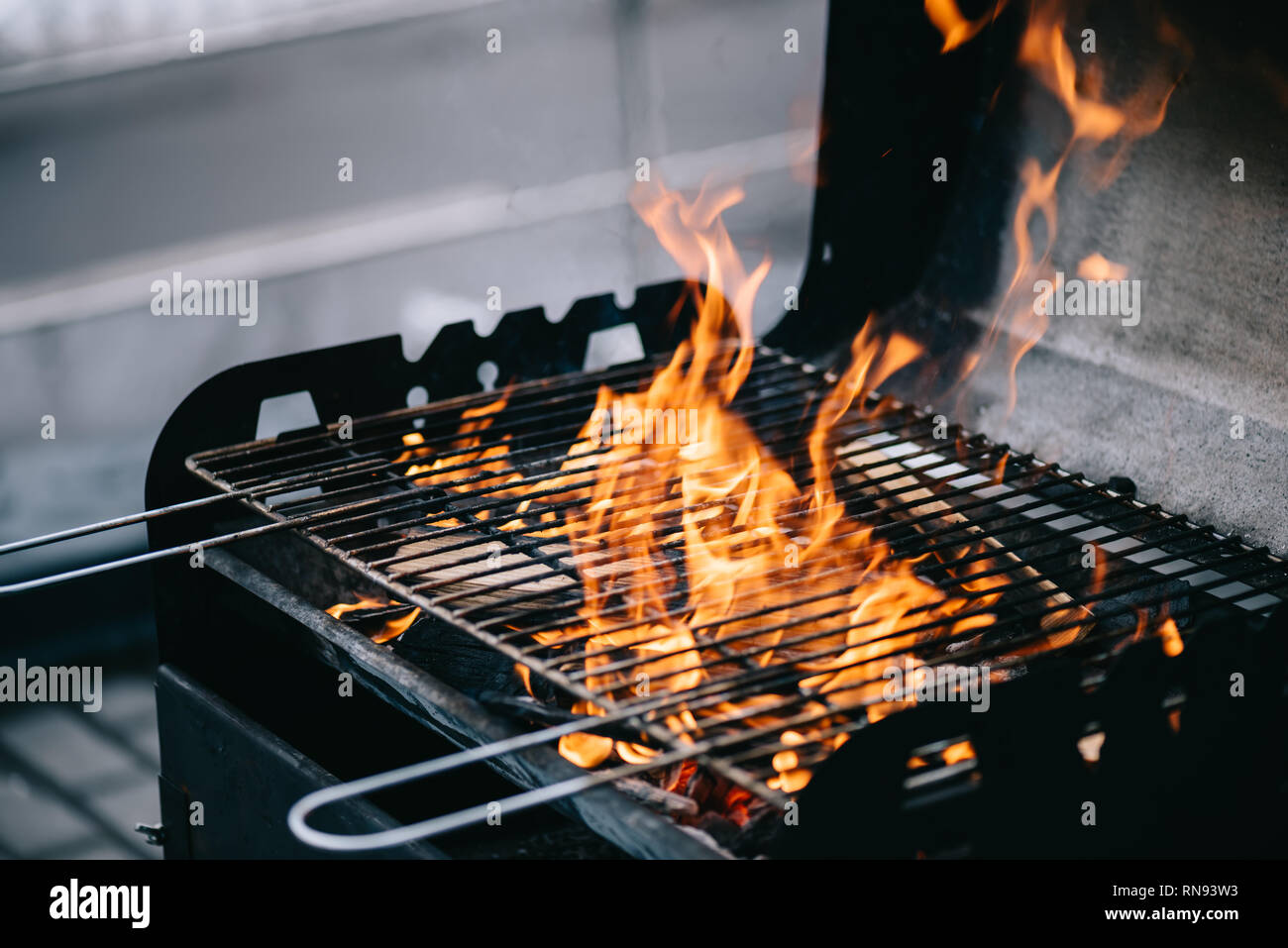 La combustione di legna da ardere con fiamma attraverso il barbecue grill  griglie Foto stock - Alamy
