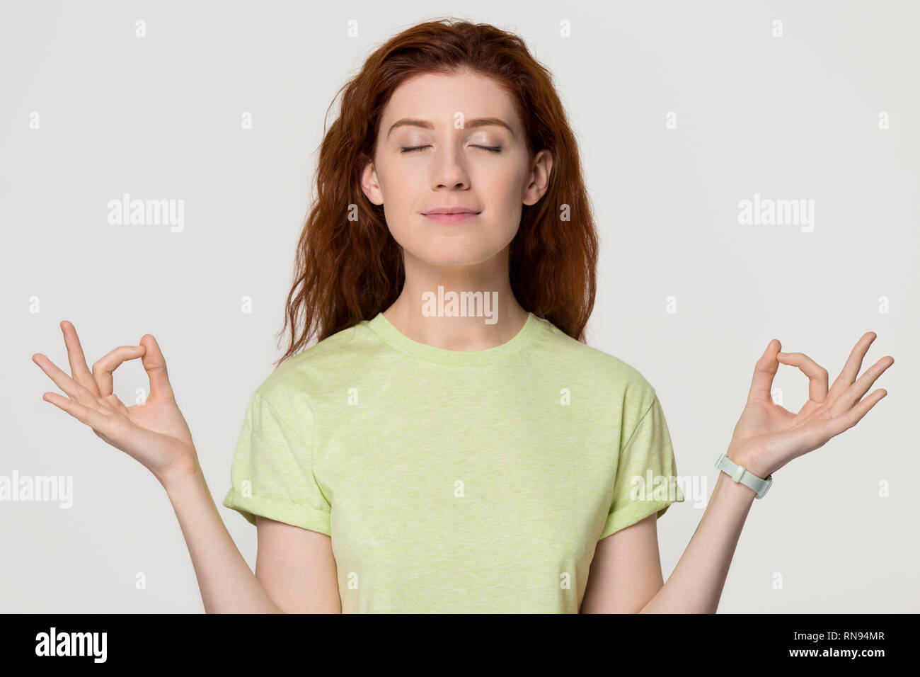 Calma sano redhead donna meditare per alleviare lo stress sensazione zen Foto Stock