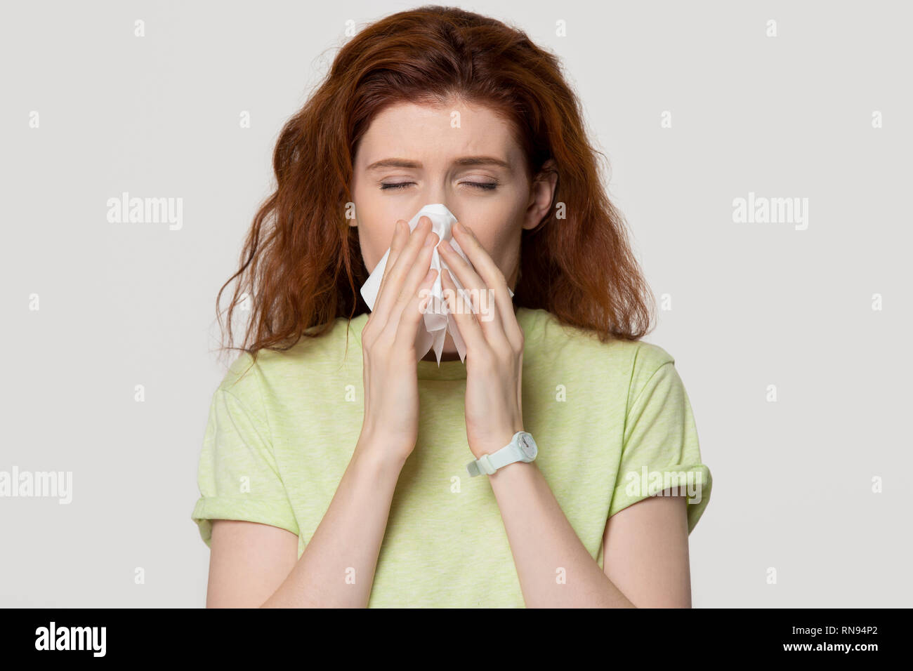 Allergia malati i capelli rossi donna soffia il naso nel tessuto ottenuto flu Foto Stock