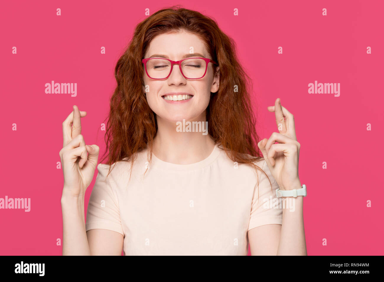 Happy funny giovane redhead una studentessa dita incrociate rendendo desiderio Foto Stock