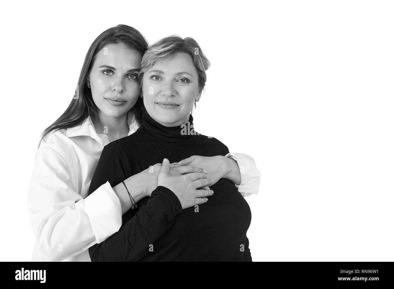 Bella sorridente figlia adulta e madre, isolato su bianco. In bianco e nero Foto Stock