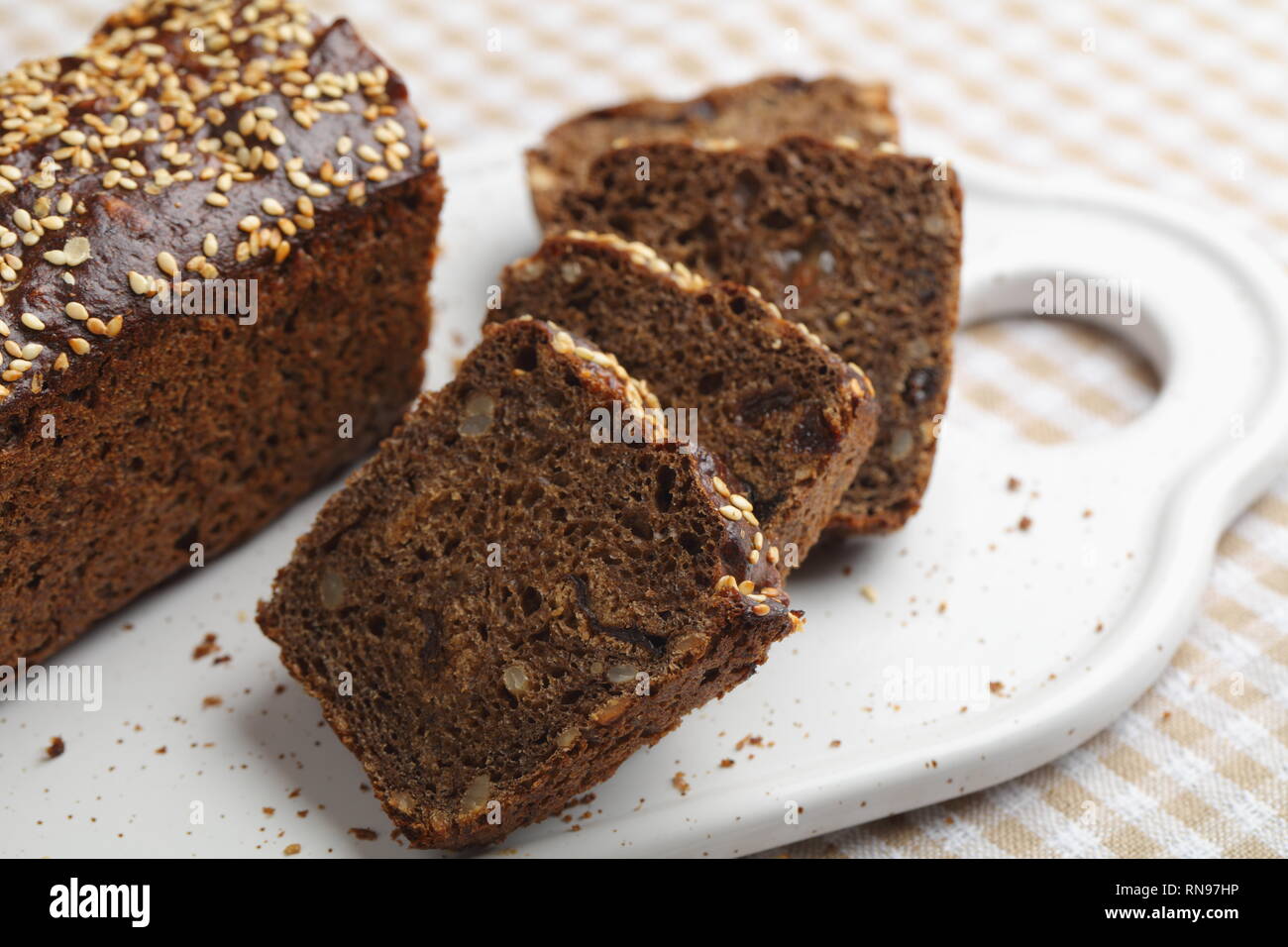 Pane di segale con chicchi di uva passa e su un tagliere Foto Stock