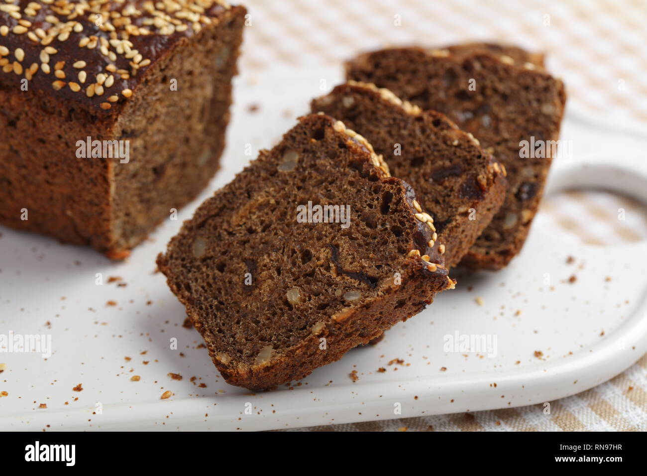 Pane di segale con chicchi di uva passa e su un tagliere Foto Stock