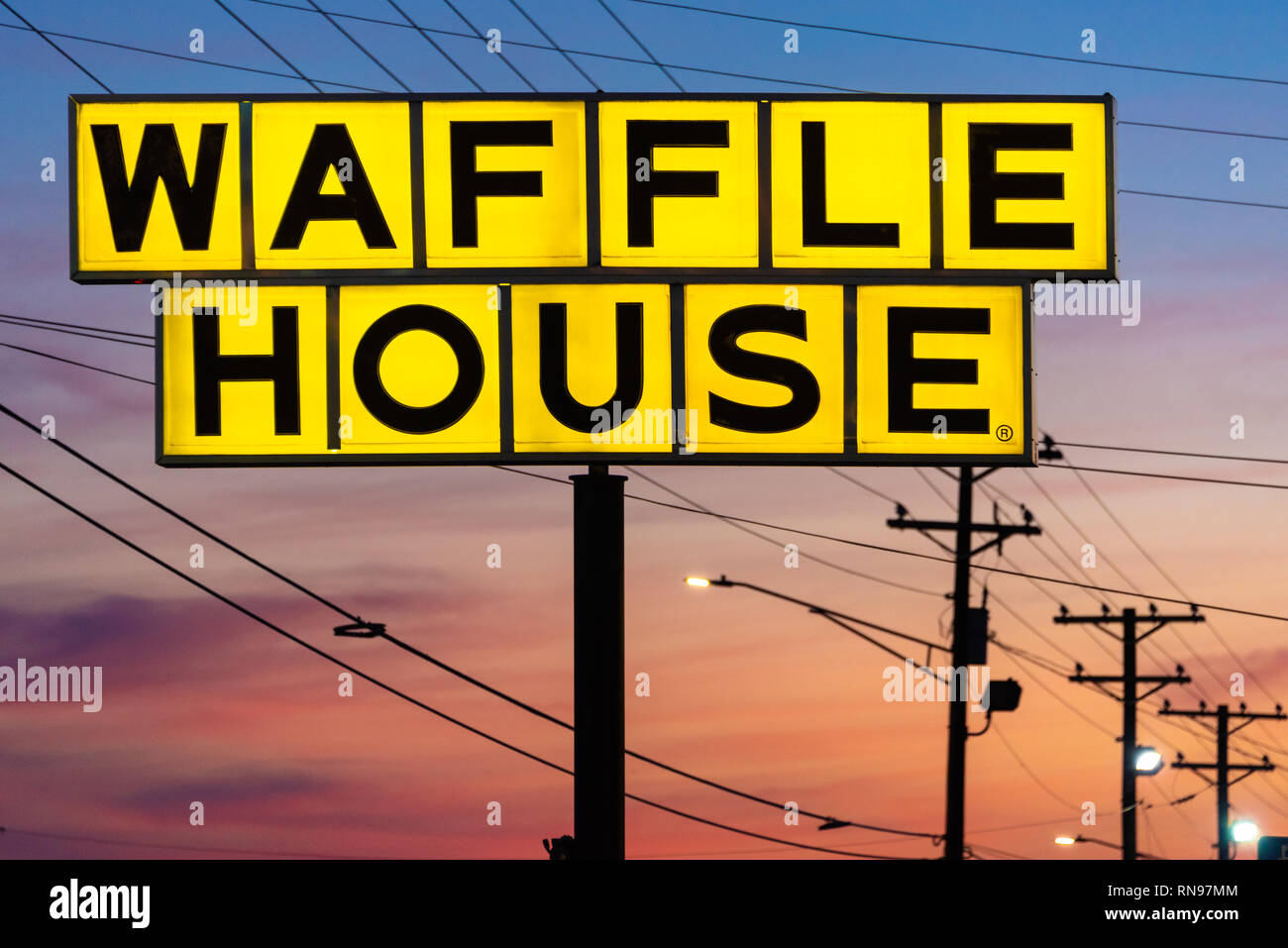 Illuminati Waffle House segno contro un cielo colorato al crepuscolo in Snellville, Georgia. (USA) Foto Stock