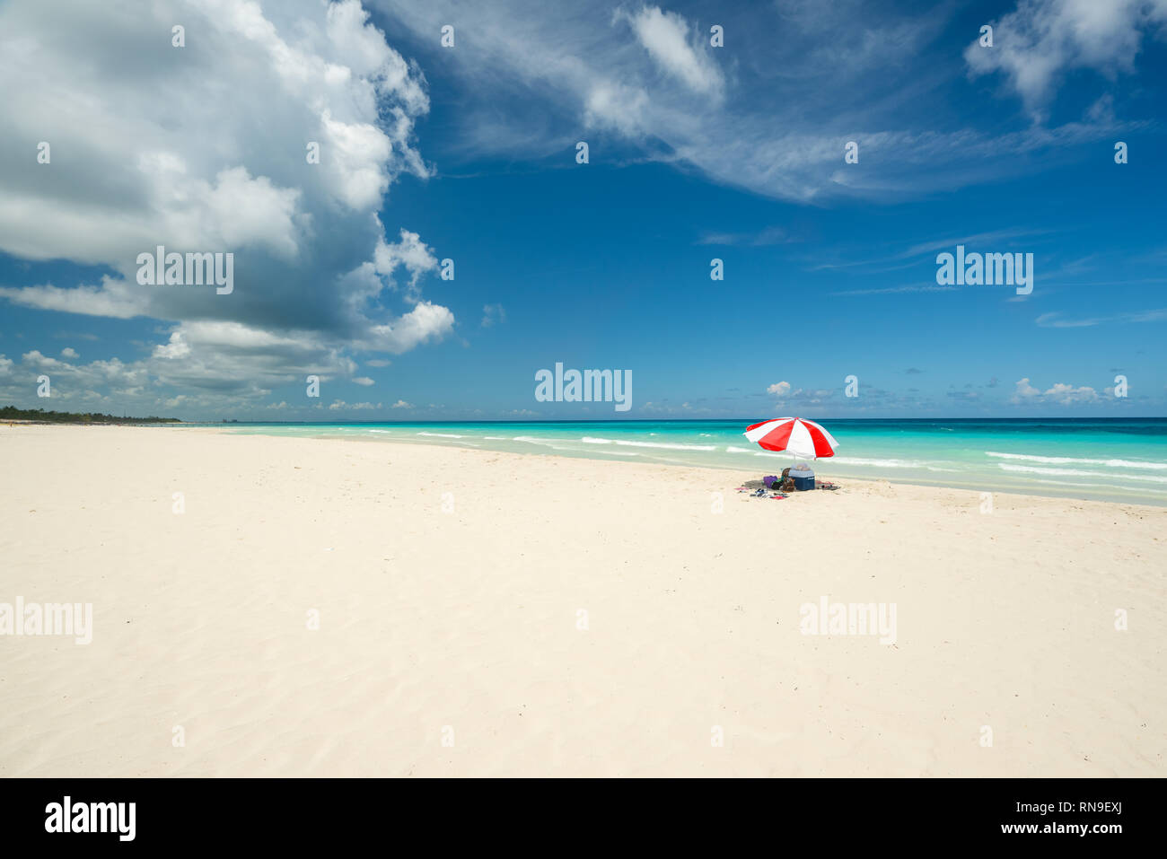 Bellissima spiaggia di Varadero durante una giornata di sole, sabbia fine e bianca e turchese e verde mare dei caraibi,sulla destra un ombrellone rosso,Cuba.concetto foto Foto Stock