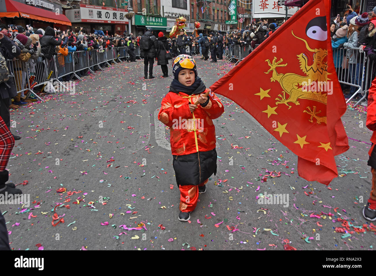 New York, Stati Uniti d'America. Xvii Feb, 2019. Ragazzo giovane camminando in il percorso della parata tenendo un drago bandiera Credito: Rachel Cauvin/Alamy Live News Foto Stock