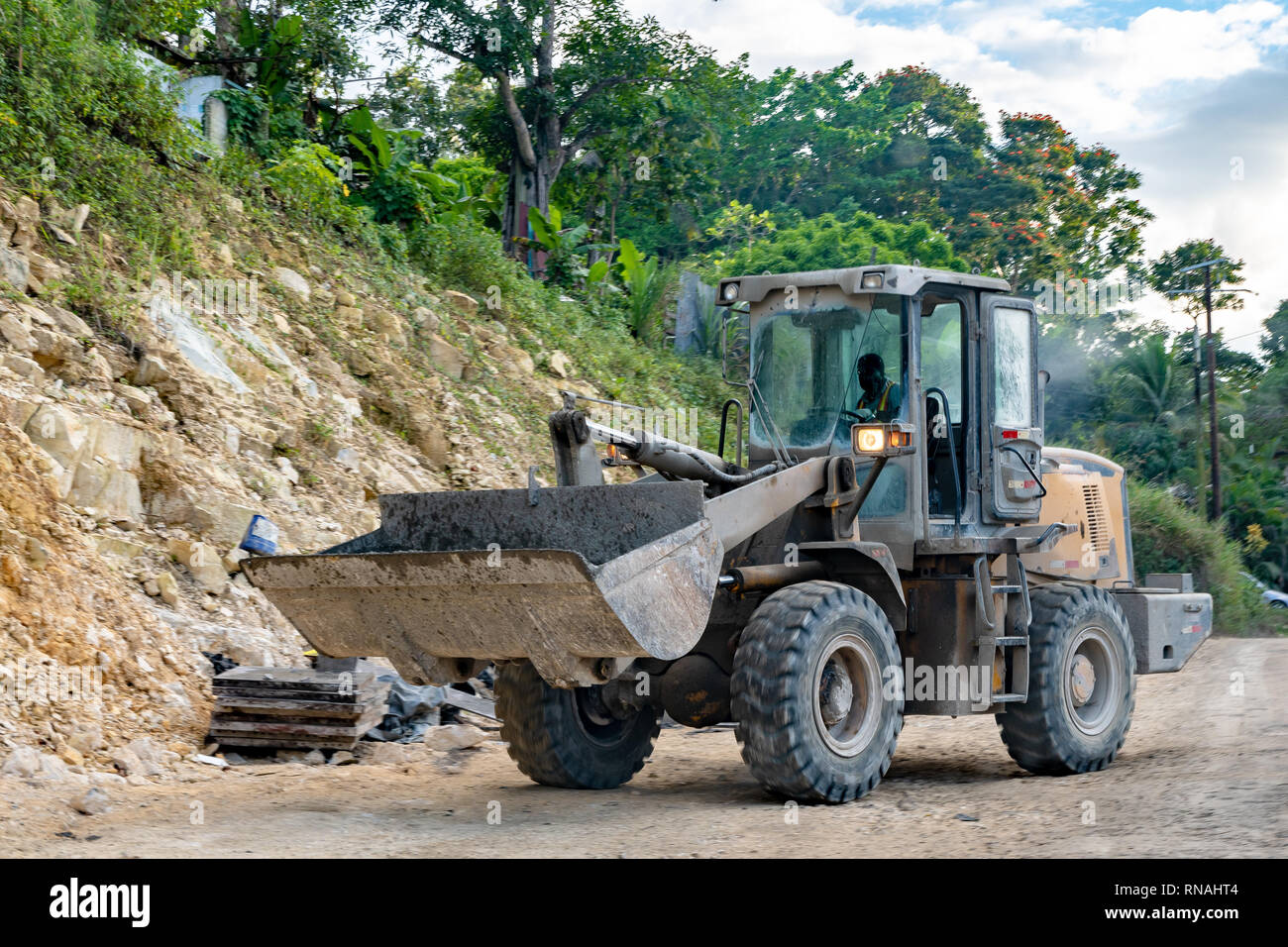 Bulldozer nel funzionamento a maschio lavoratore edile sulla carreggiata sito in costruzione nel mondo rurale Foto Stock